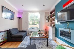 a living room with a couch and a table at Master En - Suite Townhouse double with Garden & Hot Tub in London
