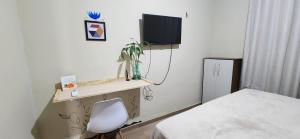 a room with a desk with a chair and a tv at Linda casa com exc. localização in Castanhal