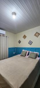 1 dormitorio con 1 cama grande y paredes azules en Linda casa com exc. localização, en Castanhal