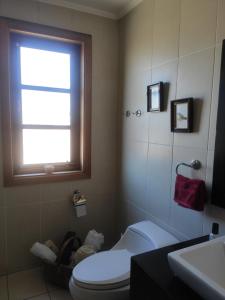 baño con aseo y lavabo y ventana en Puerto Varas, habitación doble, en Puerto Varas