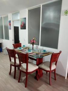 a dining room table with chairs and a vase with flowers at Apto vacacional DENIS T in Tunja