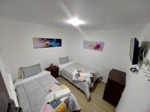 a room with two beds and a tv in it at Apto vacacional DENIS T in Tunja