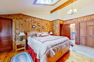 a bedroom with a large bed and wooden walls at American Dream on Lake Winnipesaukee in Meredith