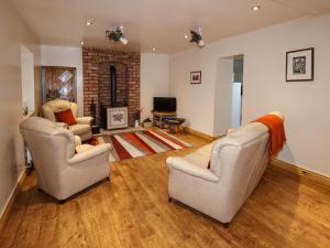 a living room with two chairs and a fireplace at The Granary in Biddulph