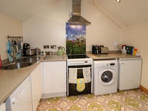 a kitchen with a dishwasher and an aquarium on the stove at The Granary in Biddulph