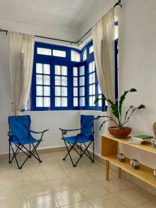 a living room with two blue chairs and a window at Itzé Hostel Boutique - Progreso in Progreso