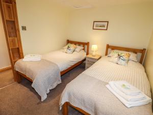 a bedroom with two beds and a lamp on a table at The Granary in Biddulph