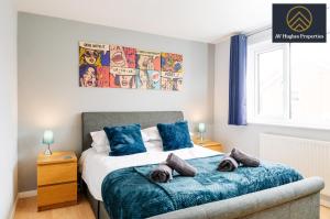 una camera da letto con letto e cuscini blu di Exclusive Two Bedroom House by AV Hughes Properties Short Lets & Serviced Accommodation Northampton For Families & Business a Kingsthorpe