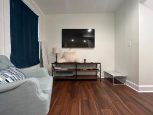 a living room with a couch and a tv on the wall at 1BR Fully Handicap Accessible Near Downtown in Greenville