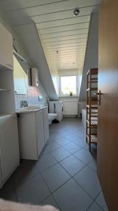 eine große weiße Küche mit einem Waschbecken und einem Fenster in der Unterkunft Appartement mit Blick ins Grüne in Viereth-Trunstadt