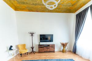 a living room with a tv and a chair at Schiller Rooms in Sibiu