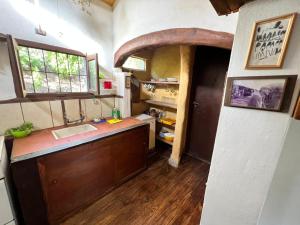 eine Küche mit einer Theke, einem Waschbecken und einem Fenster in der Unterkunft El vallecito in La Ramada