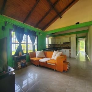 een woonkamer met een oranje bank en een keuken bij Casa de campo in Restrepo