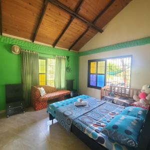 1 dormitorio con 1 cama, 1 silla y ventanas en Casa de campo, en Restrepo