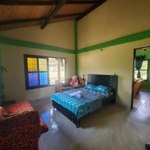 een slaapkamer met een bed in een kamer met groene muren bij Casa de campo in Restrepo