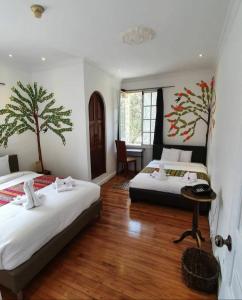 キトにあるHotel Boutique Spa Villa de Santのベッド2台と机が置かれた寝室 +56枚の写真