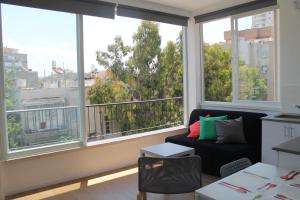 a living room with a couch and a large window at Arlozorov Bat Yam Beach in Bat Yam