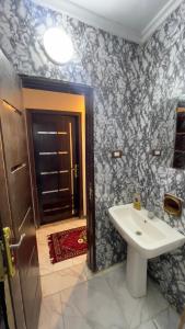 a bathroom with a sink and a toilet and a door at Tabia Tower City center aswan in Aswan