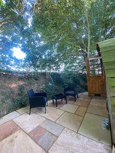 a patio with two chairs and a table at The Nest cabin in Ipswich