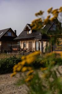 une maison avec une clôture devant elle dans l'établissement "Polne Domki" Osada Drewniana w Harklowej, à Harklowa