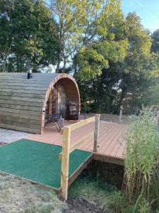 a wooden deck with a bench and a house at The Nest cabin in Ipswich