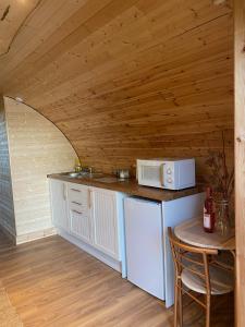 cocina con nevera blanca y microondas en The Nest cabin, en Ipswich