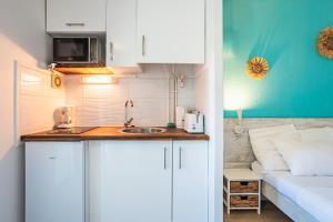 uma pequena cozinha com um lavatório ao lado de um sofá em Studio élégant Marina du Gosier em Pointe-à-Pitre