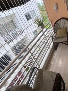 a balcony with two chairs and a window at Hermoso residencial con piscina licey al medio in Licey al Medio
