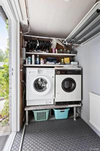 eine Waschküche mit Waschmaschine und Trockner in der Unterkunft Ein Zuhause zum Wohlfühlen in Olofström