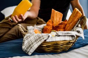a basket of bread and a person holding a cell phone at L'Alcôve Dorée - Appart'Hôtel SPA - Melina & Alfred Agen in Agen