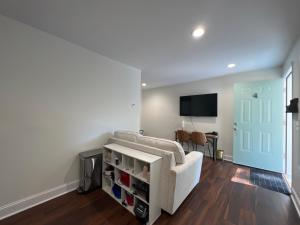 a living room with a white couch and a flat screen tv at 1BR Near Downtown & Mountain Goat Coffee in Greenville