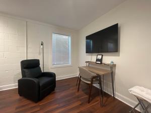 a room with a chair and a desk and a television at 1BR Near Downtown & Mountain Goat Coffee in Greenville