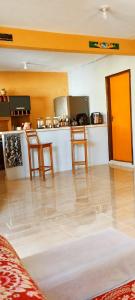 a room with a kitchen with two chairs and a counter at Casa mãe Terra in Camacari