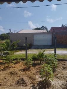 a house with a garage in front of it at Casa mãe Terra in Camacari