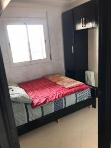 a small bedroom with a bed and a window at Tanja baliya in Tangier