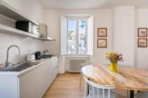 cocina con mesa de madera con sillas y fregadero en Fisher's Apartment in Testaccio en Roma