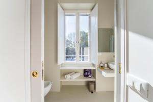 een badkamer met een wastafel en een raam bij Fischer's Apartment in Testaccio in Rome +23 foto's