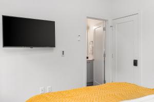 a bedroom with a flat screen tv on a white wall at Palpatine Sith Lord Suite in Seattle