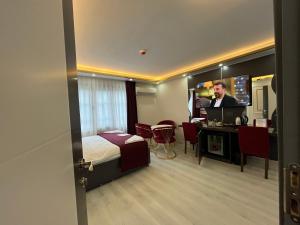 Habitación de hotel con cama, escritorio y TV. en Lale Sultan Hotel, en Estambul