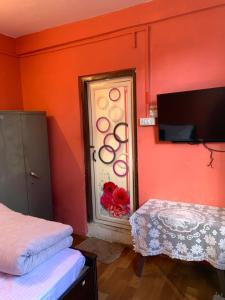 a room with orange walls and a door with a window at Solo Stays - Backpacker hostel in Darjeeling