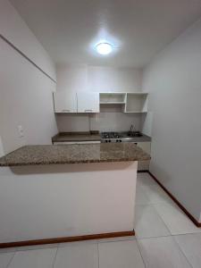a kitchen with white cabinets and a counter top at Aquarius Flat Studio 601 in Santa Cruz do Sul