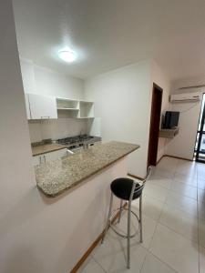 a kitchen with a counter and a stool in a room at Aquarius Flat Studio 601 in Santa Cruz do Sul
