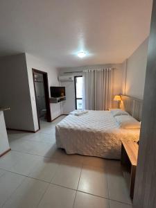 1 dormitorio con 1 cama grande y TV en Aquarius Flat Studio 601, en Santa Cruz do Sul