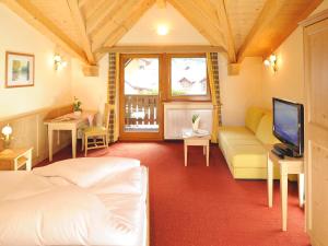 a bedroom with a bed and a couch and a tv at Hotel Neue Post in Sölden