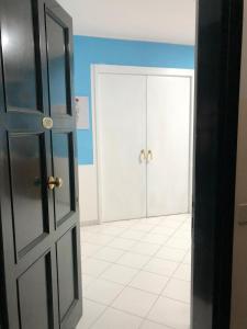 um quarto vazio com duas portas e um piso de azulejo em La casa di Dafne em Messina