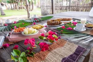 ein Picknicktisch mit Essen und Blumen darauf in der Unterkunft Orla Atins in Atins