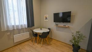 a small room with a table and chairs and a television at Big studio apt.on Liberty Square in Tbilisi City