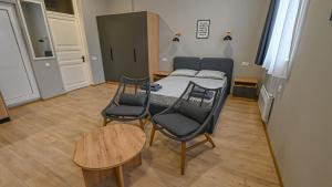 a bedroom with a bed and two chairs and a table at Big studio apt.on Liberty Square in Tbilisi City