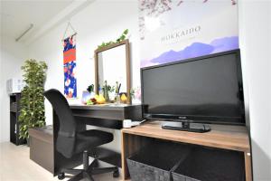 a large flat screen tv sitting on top of a desk at Carid Shiraishi In front of the station - Vacation STAY 15492 in Sapporo