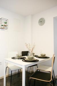 a white dining table with chairs and a white wall at Apartman Grey in Jastrebarsko